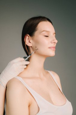 Bir kozmetikçi tarafından diş gıcırdatma için Bruksizm damgası. Bir estetik tıp kliniğinde botulinyum toksinle tedavi için Bruksizm yüz işaretleme