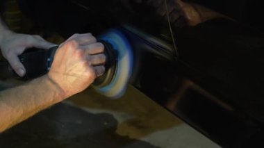 Araba cilalama ve 4K video detayı. Yörünge parlatıcısı olan eller, temizlik merkezinde siyah araba cilalayan. Yörüngesel cilalayıcı ile cilalanan sert balmumu araba yakın plan çizikleri kaldırmak için.