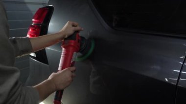 Yörünge cilasıyla cilalanan Hard Wax 'ın 4k' lık videosu yakın plan çizikleri silmek için. Araba cilalama ve detaylı işlemler. Yörünge parlatıcısı olan eller, temizlik merkezinde siyah araba cilalamak..