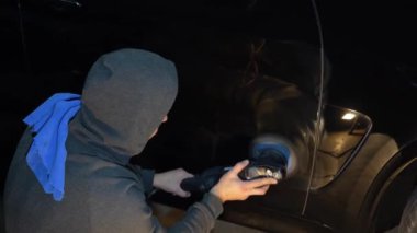 Yörünge cilasıyla araba cilalamak 4K 'lık çizikleri silmek için. Otomobil servisi çalışanı araba için son cilalamayı yapıyor.