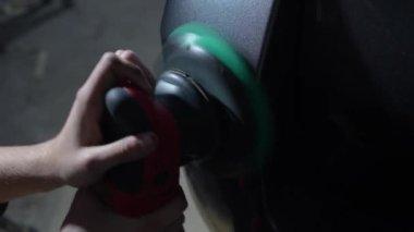 Yörünge cilasıyla cilalanan sert balmumu araba yakın plan çizikleri silmek için. Otomatik servisin detaylandırılmasında 4k video çalışma süreci.