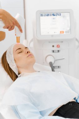 Klinikte IPL lazer teçhizatıyla Rosacea tedavisi. Boyun bölgesinde, güzellik uzmanının IPL cihazıyla nakledilen gemiler. Yüksek kaliteli lazer cihazlarıyla hızlı rosacea tedavisi