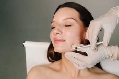 Güzel ve elastik yüz ve çene hatları için Botulinum toksin enjeksiyonu prosedürü. Çene şeklini botulinyum toksin enjeksiyonuyla düzeltmeye yarayan plastik.