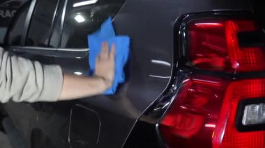 Otomobil servisi videosunda mikrofiber ve deterjanla kurulanan el arabası. Araba yıkadıktan sonra temizlikçi kuru araba..
