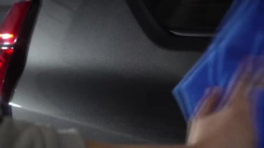 Araba yıkama videosundan sonra temizlikçi kuru araba. Otomobil servisinde mikrofiber ve deterjan ile kurutulan el arabası..