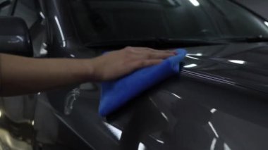 Detaylı serviste mikro fiber bez kullanarak araba cilalamak. Bir aracı cilalamak ve cilalamak. Temizlik servisinde havluyla araba valesi..