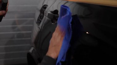 Detaylı serviste mikro fiber bez kullanarak araba cilalamak. Bir aracı cilalamak ve cilalamak. Temizlik servisinde havluyla araba valesi..