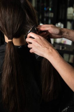 Saç kesme makinesi kadın saç stilleri için. Kuaför esmer bir müşteriye kestirme yol yapıyor. Yeni bir kısa saç modeli yaptırıyorum.