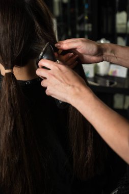 Kuaför esmer bir müşteriye kestirme yol yapıyor. Yeni bir kısa saç modeli yaptırıyorum. Saç kesme makinesi kadın saç stilleri için.