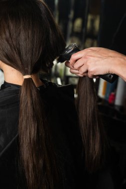 Kuaför esmer bir müşteriye kestirme yol yapıyor. Yeni bir kısa saç modeli yaptırıyorum. Saç kesme makinesi kadın saç stilleri için.