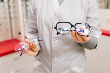 Optik klinikte kontrol edildikten sonra oftalmolog farklı çerçevelerle gözlük sunuyor. Gözlük kullanarak göz hastalıklarını düzeltmek