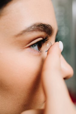 Yüksek kaliteli kontakt lenslerle göz sağlığını düzeltiyorum. Kadın, astigmat tedavisi için gözüne kontak lens takıyor..