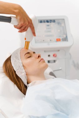 Klinikte IPL lazer teçhizatıyla Rosacea tedavisi. Boyun bölgesinde, güzellik uzmanının IPL cihazıyla nakledilen gemiler. Yüksek kaliteli lazer cihazlarıyla hızlı rosacea tedavisi