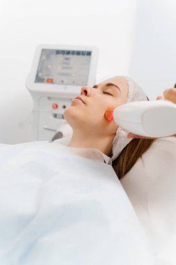Hasta yüzünde IPL ultrason lazerle büyümüş küçük damarların çıkarılması. Dermatolog tarafından yapılan IPL lazer tedavisi. Güzellik kliniğinde acısız rosacea tedavisi.