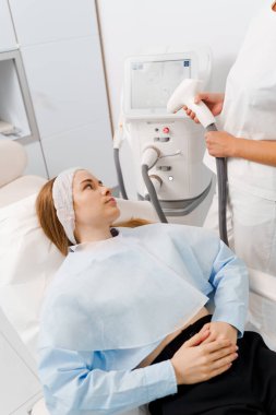 Hasta yüzünde IPL ultrason lazerle büyümüş küçük damarların çıkarılması. Dermatolog tarafından yapılan IPL lazer tedavisi. Güzellik kliniğinde acısız rosacea tedavisi