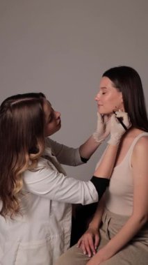 Çenenin dolgularla düzeltilmesi. Çene 4k dikey videosunun köşelerini birleştirmek. Profesyonel güzellik tedavisi. Elmacık kemiklerinin düzeltiliyor