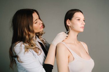 Bir kozmetikçi tarafından diş gıcırdatma için Bruksizm damgası. Bir estetik tıp kliniğinde botulinyum toksinle tedavi için Bruksizm yüz işaretleme