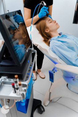 Kozmetik uzmanı tarafından kadının yüzündeki Hidrosel Temizleme Güzellik Prosedürü. Güzellik kliniğindeki yüksek kaliteli ekipmanlarla yüz temizleme prosedürleri