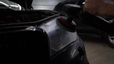 Araba cilası, bulutlu far, 4K 'lık görüntü yükle. Yörünge parlatıcısı olan eller, temizlik merkezinde siyah araba cilalayan. Yörüngesel cilalayıcı ile sert balmumu araba far cilalama çizikler kaldırmak için.