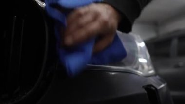 4K video servisinde mikro fiber bez kullanarak araba farlarını parlatmak. Bir aracı cilalamak ve cilalamak. Farları havluyla silmek. Profesyonel araba temizliği.