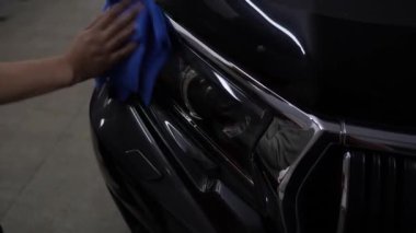 Bir aracı cilalamak ve cilalamak. 4K havluyla farları siliyorum. Profesyonel araba temizliği. Detaylandırma servisinde mikro fiber bez kullanarak araba farlarının parlatılması.