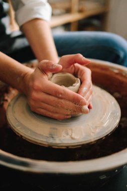 Potter çömlek atölyesinde seramik bir kase yapıyor. Eşsiz bir seramik şekil oluşturma süreci