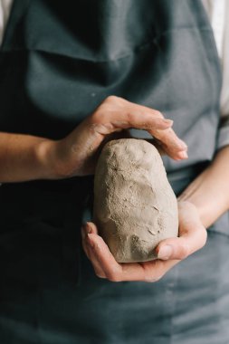 Seramik ürünler üretme süreci. Potter ıslak bir kil parçasını ellerinde tutuyor ve onu şekillendiriyor.