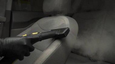 Servis videosunda araç koltuklarının sıcak hava temizliği 4K. Araba koltuğunu tozdan ve pislikten temizlemek ve dezenfekte etmek için elle detaylı prosedür.