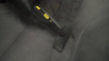 Otomobil 4K videosunu dezenfekte etmek ve temizlemek için buhar makinesini kullanarak arabadaki koltukları buharla temizliyor. Buharlı araç koltuklarının ayrıntıları temiz.