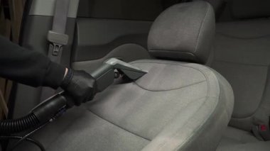 Tekstil araba koltuğundaki toprak çıkarma işlemi için 4K ekstraktör temizleme makinesi videosu kullanılıyor. Kuru temizleme, kuru temizleme makinesiyle araba koltuğundan toprak ve tozu kaldırıyor..