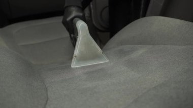 Tekstil araba koltuğu, çıkarma suyu ve kuru temizleme makinesi 4K video deterjanı. Kuru temizleme, kuru temizleme makinesiyle araba koltuğundan toprak ve tozu kaldırıyor..