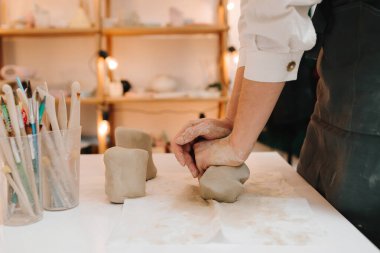 Dişi çömlekçi heykel yapmadan önce bir parça kil sarar. Seramik çanak çömlek yapmak için kil hazırlanıyor