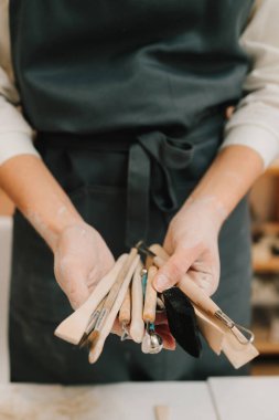 Potter 'da kil yontma için el aletleri var. Seramik çanak çömlek kalıbı için ahşap el işi araçları