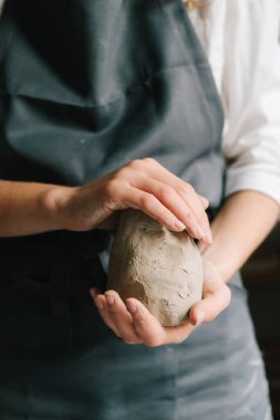 Potter ıslak bir kil parçasını ellerinde tutuyor ve onu şekillendiriyor. Seramik ürünler oluşturma süreci