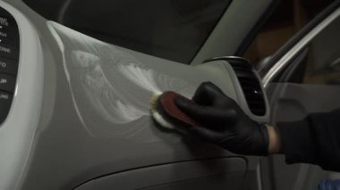 İşlem 4k videosu detaylandırılıyor. Aracın içindeki 4K video fırçasıyla deterjanı karalamak. Araç içinin temiz unsurlarını temizleme işçisiName.