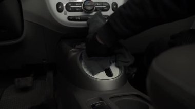 Dişlilere deterjan sürüp arabanın içini kuru temizleme için gösterge paneline süpürüyorsun. Profesyonel eldiven temizleyicisi, leke ve kiri temizlemek için vites kutusuna deterjan sürüyor..