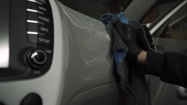 İşlem 4k videosu detaylandırılıyor. İşçi, arabanın içini kurulama işlemi sırasında mikro fiber bez kullanarak arabaları temizler.