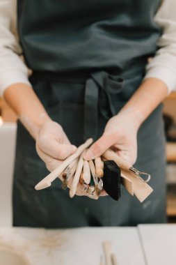 Potter 'da kil yontma için el aletleri var. Seramik çanak çömlek kalıbı için ahşap el işi araçları