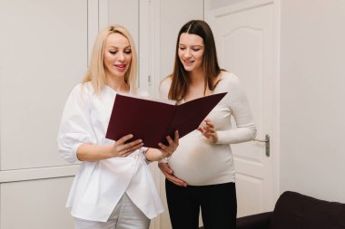 Jinekolog hamilelik kontrolü için analiz testleri gösteriyor. Jinekolog, tıbbi sonuçları hamile hastaya bildirdi.