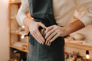 Esnaf siyah önlüğü farklı çömlekçi aletleri bulundurur. Farklı çömlekçi enstrümanları seti