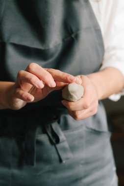 Potter ıslak bir kil parçasını ellerinde tutuyor ve onu şekillendiriyor. Seramik ürünler oluşturma süreci