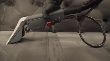 Toz ve kiri ayıklamak, koltuktan lekeleri çıkarmak, sökücü kullanarak döşenmiş mobilyaları temizlemek 4K video. Kanepe ve yastıkları kuru temizleme sökücüsüyle tozdan ve çamurdan ferahlatıyor..
