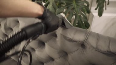 Toz ve kiri ayıklamak, koltuktan lekeleri çıkarmak, sökücü kullanarak döşenmiş mobilyaları temizlemek 4K video. Kanepe ve yastıkları kuru temizleme sökücüsüyle tozdan ve çamurdan ferahlatıyor..