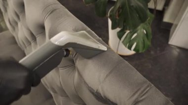 Toz ve kiri ayıklamak, koltuktan lekeleri çıkarmak, sökücü kullanarak döşenmiş mobilyaları temizlemek 4K video. Kanepe ve yastıkları kuru temizleme sökücüsüyle tozdan ve çamurdan ferahlatıyor..