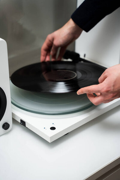 Musicians hands adjusting vinyl disc on a needle player close-up. Setting up vinyl speaker system