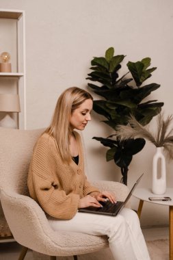 Çekici kız öğrenci internette oturuyor ve çalışıyor. Uzaktan eğitim. Bilgisayarlı iş kadını yatak odasında çalışıyor.