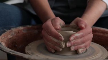 Kadın çömlekçi, çömlekçi tekerleği 4K videosunda kilden bir ürün oluşturuyor. Üretimde seramik çanak çömlek yontma süreci
