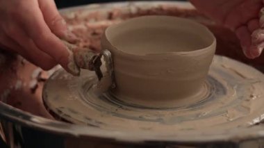 Atölyede seramik çanak çömlek yapmak. Kadın, çömlekçi çarkında kilden kase heykeli yapıyor. 4K video.