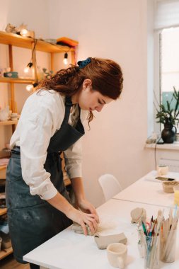 Sanat stüdyosunda kadın esnaf kil kalıplar. Toprak malzemesi yapmak için kil yontuyorum