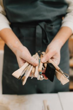 Seramik çanak çömlek kalıpları için ahşap el aletleri. Potter kil yontma için el sanatları aletleri tutuyor